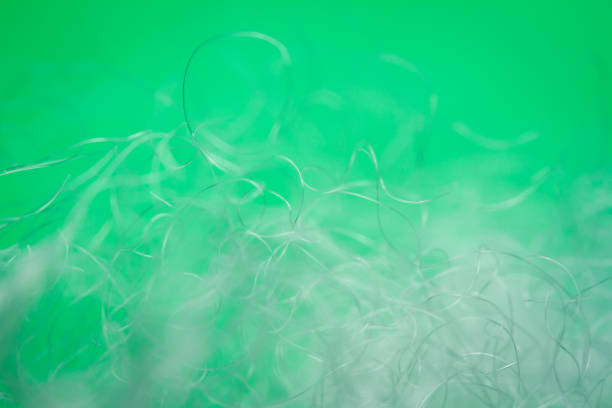 Extreme macro of polyester stable fiber on green background. Selective focus, shallow depth of field. Abstract dreamy background