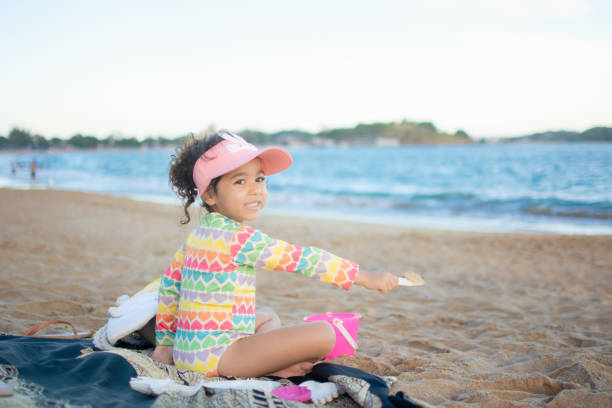 Adorable little girl playing on a sandy beach on a sunny day.Happy with her family.