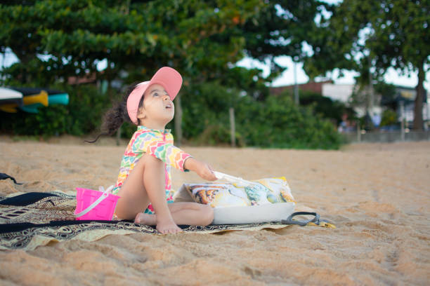 Adorable little girl playing on a sandy beach on a sunny day.Happy with her family.