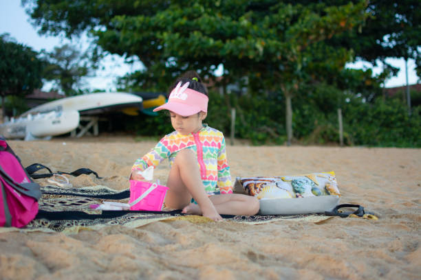 Adorable little girl playing on a sandy beach on a sunny day.Happy with her family.