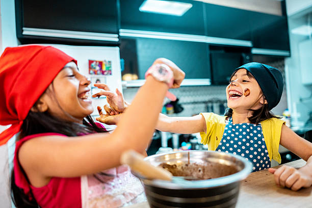 istock Sisters playing and preparing cake in the kitchen 2206229026