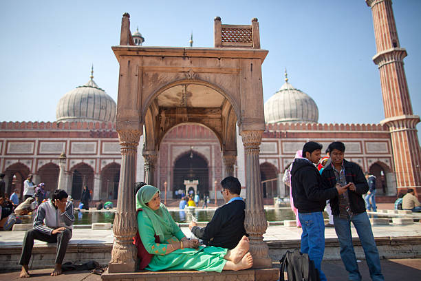 February 9, 2013 - New Delhi, India.  Muslims and non Muslims alike spend time in the mosque which is a masterpiece of Mughal architecture; the Jama Masjid stands as an emblem of Delhi's cultural heritage