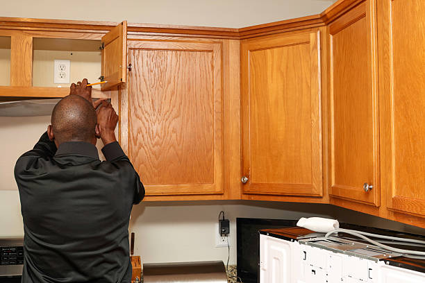 A portrait of a black man installing a new microwave