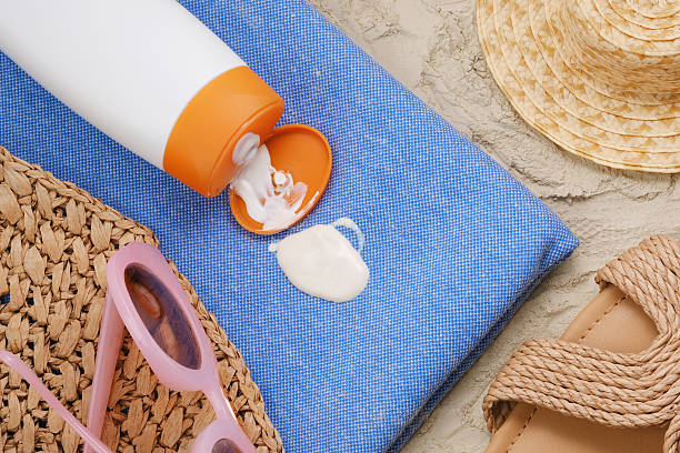 Spilled cream on a blue carpet. Close up spilled sunscreen on blue beach towel on the sand. Concept of daily stains on clothes. top view sunshade stock pictures, royalty-free photos & images