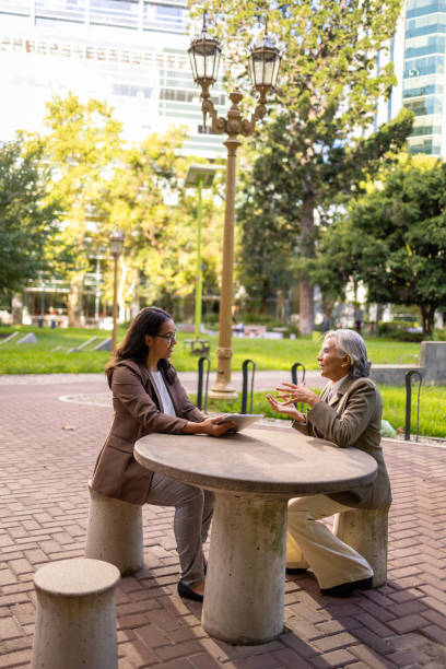 Two professional women collaborating at an outdoor business district setting