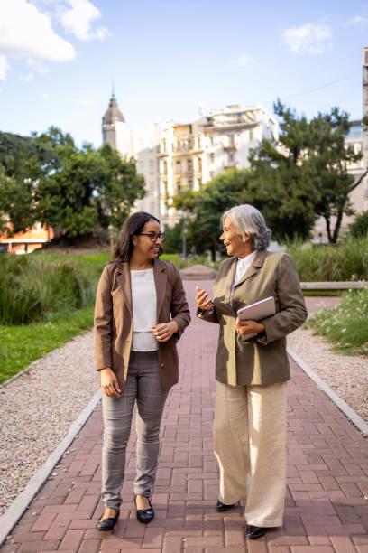 istock Two businesswomen conversing in an urban park environment 2206234449