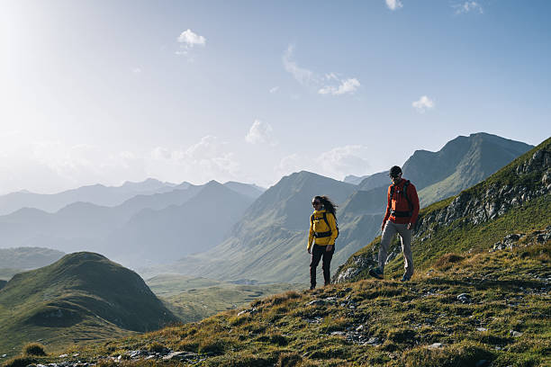 istock Couple hike across mountain meadow at sunrise 2206235786