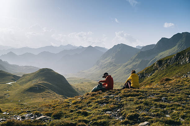 istock Hikers sit in mountain meadow at sunrise 2206235831
