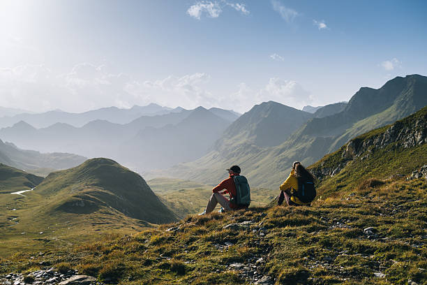istock Hikers sit in mountain meadow at sunrise 2206235841