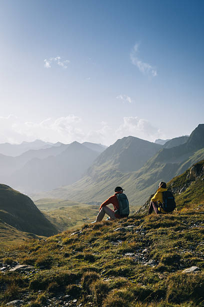 istock Hikers sit in mountain meadow at sunrise 2206235860