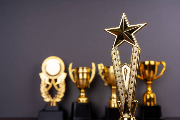 istock Standing golden trophy cups with on of them is focused on. 2206236487