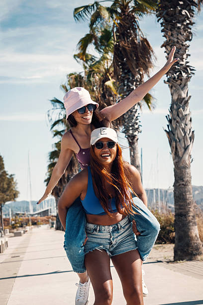 istock Two beautiful friends having fun while posing in front of the camera by the beach 2206237283