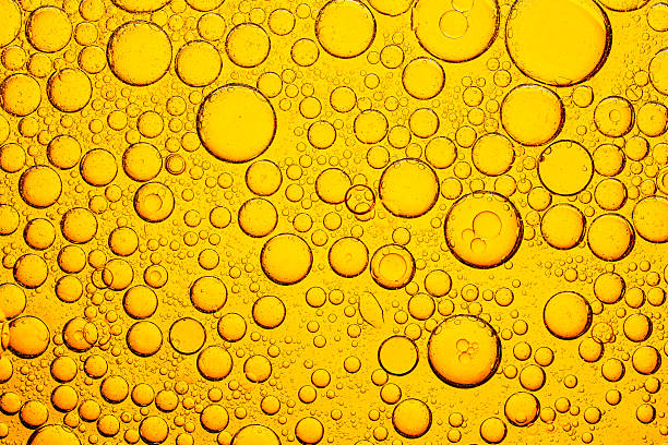 istock Yellow macro bubble texture,Close up of golden liquid, bubbles, and pipette,Processed collage of golden yellow oil bubbles texture. Background for banner, 2206239505
