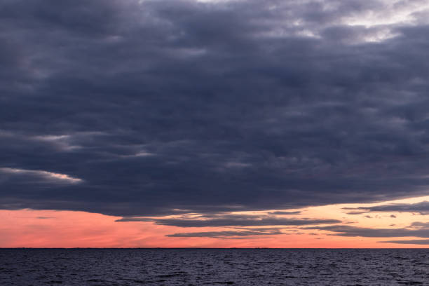 Dramatic sunset over a calm ocean with vibrant colors and extensive clouds