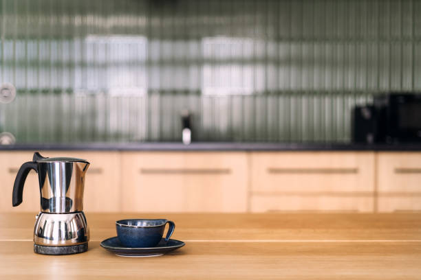 istock Modern kitchen setting featuring a coffee pot and cup on a wooden countertop 2206241762