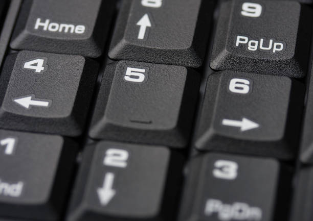 Detailed view of a numeric keypad on a computer keyboard, highlighting the arrangement and labels of keys such as numbers and functions. The image captures the texture and design typical in contemporary office environments.