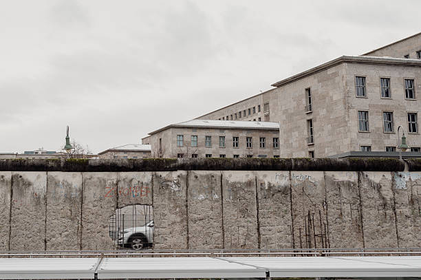 blick auf die ehemalige berliner mauer mit einem loch, durch das ein auto zu sehen ist - berliner mauer stock-fotos und bilder