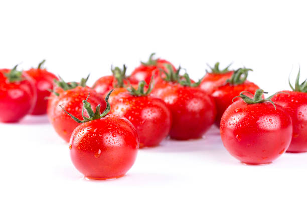 A cluster of bright red tomatoes showcases droplets of water, hinting at freshness. Their plump shape and vibrant color create an appealing presentation, ideal for salads, sauces, or garnishes.