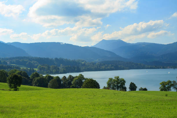 istock Lush green landscape with tranquil lake and distant mountains in summer sunlight 2206242795