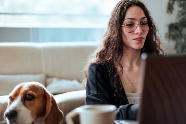 istock Young woman working at home with her dog by her side 2206248326