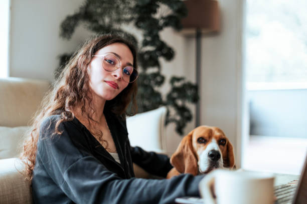 istock Young woman working at home with her dog by her side 2206248374