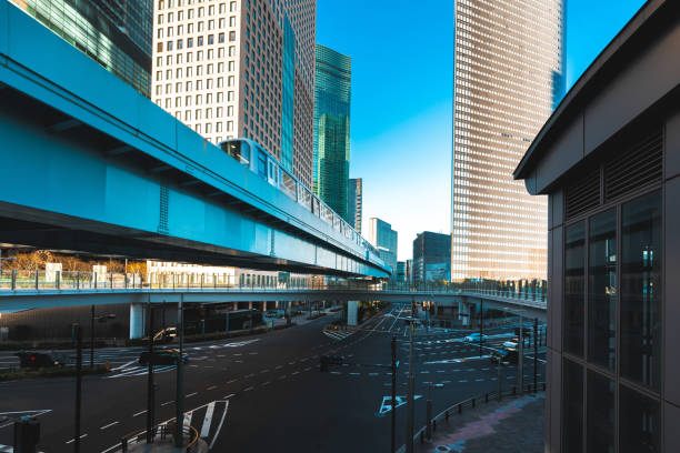 Elevated train travels through a modern cityscape in tokyo, japan, showcasing the city's advanced transportation system and urban development