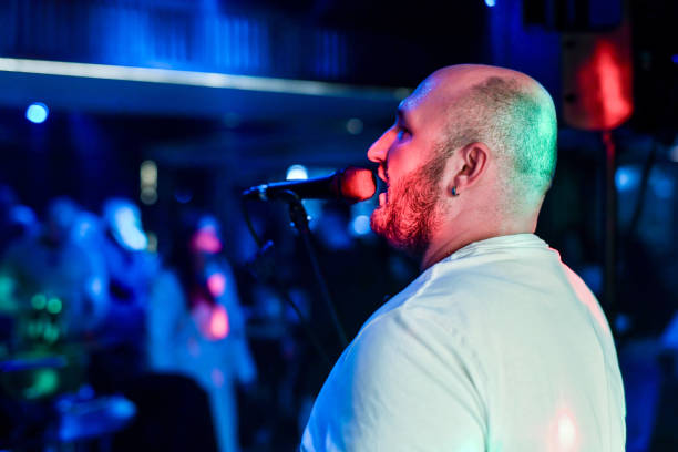 istock Man Singing on Stage Under Vibrant Lights During a Live Performance 2206248859