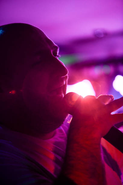 istock Man Singing on Stage Under Vibrant Lights During a Live Performance 2206248880