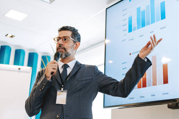 istock Mature man speaking into microphone, business presentation 2206249536