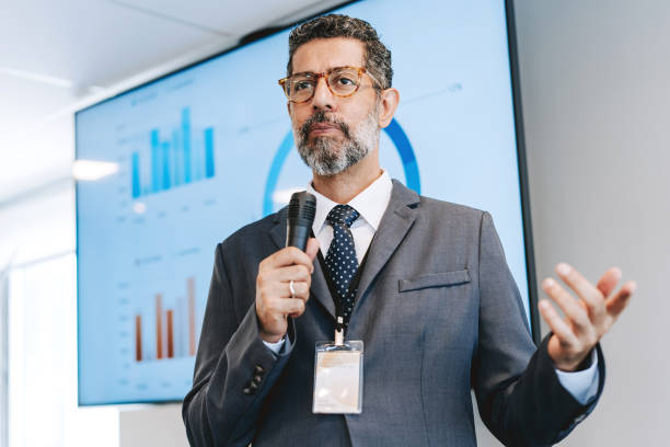 istock Mature man speaking into microphone, business presentation 2206249550