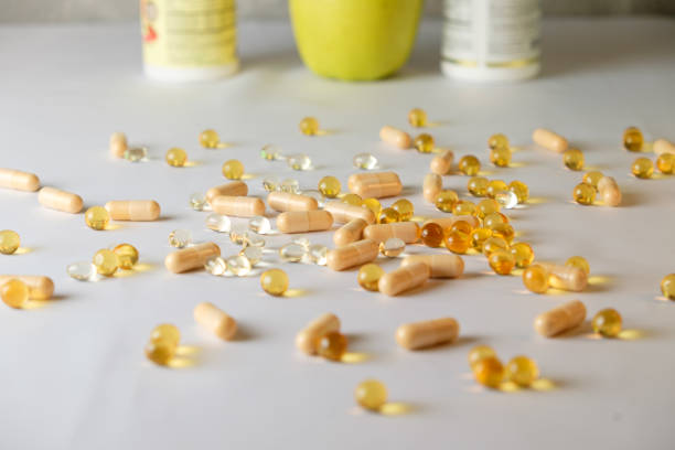 istock Nutritional supplements spread across a table with fresh produce nearby 2206250710
