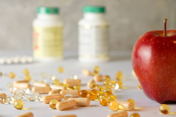 Nutritional balance with supplements and fresh fruit on a kitchen counter