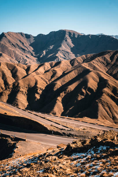 Aerial view of distant curving highway in arid mountains