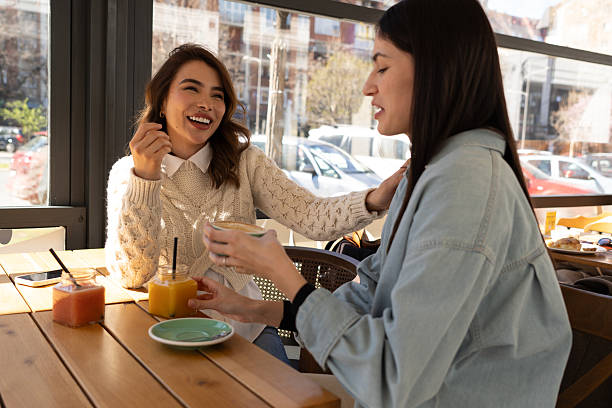 istock Two young women enjoying breakfast and talking at a cafe 2206251284