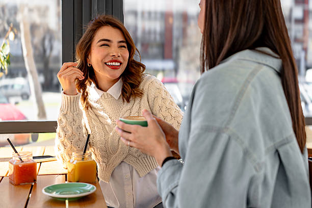 istock Two happy young women chatting and drinking coffee in a bar 2206251301