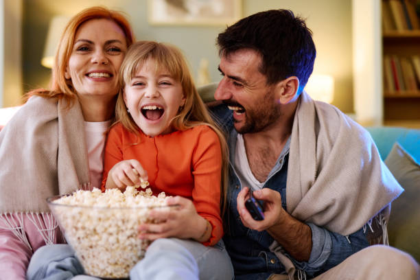 istock Family laughing and eating popcorn while watching tv 2206252021