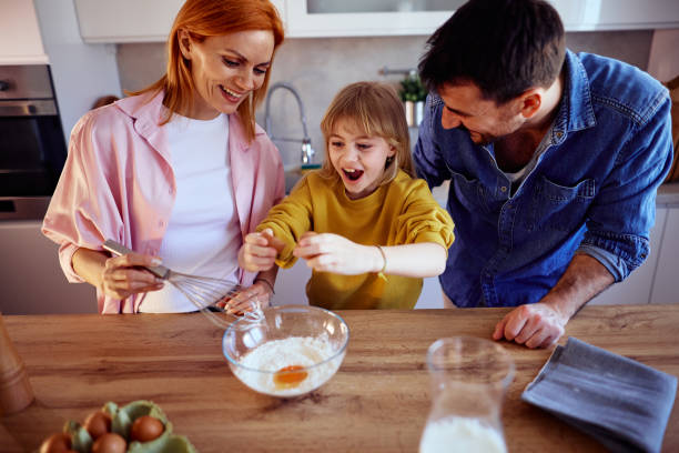 istock Happy family making a cake together in their kitchen 2206252089