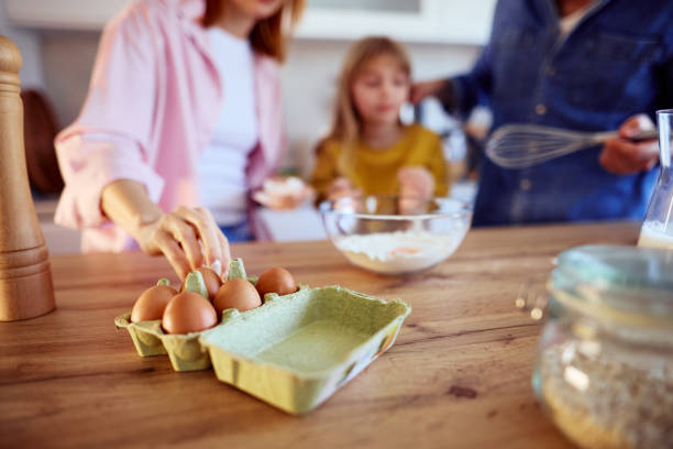 istock Family preparing a cake in the kitchen taking eggs from the box 2206252106