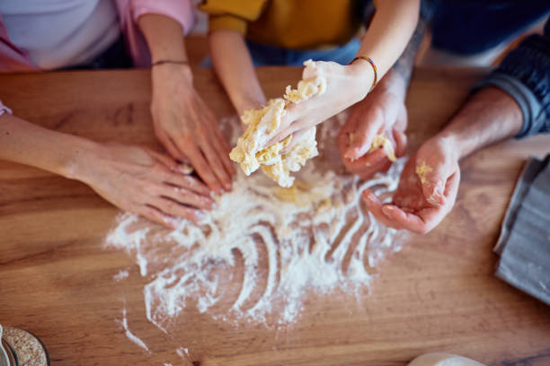 Family kneading dough together in the kitchen