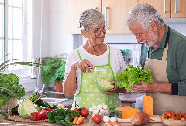 istock Attractive senior couple working together in home kitchen preparing vegetables. Caucasian elderly smiling people retirees enjoying healthy eating 2206253148