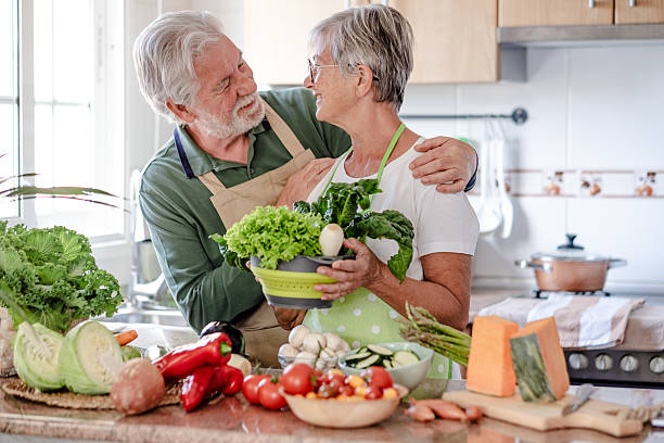 istock Attractive senior couple working together in home kitchen preparing vegetables. Caucasian elderly smiling people retirees enjoying healthy eating 2206253314