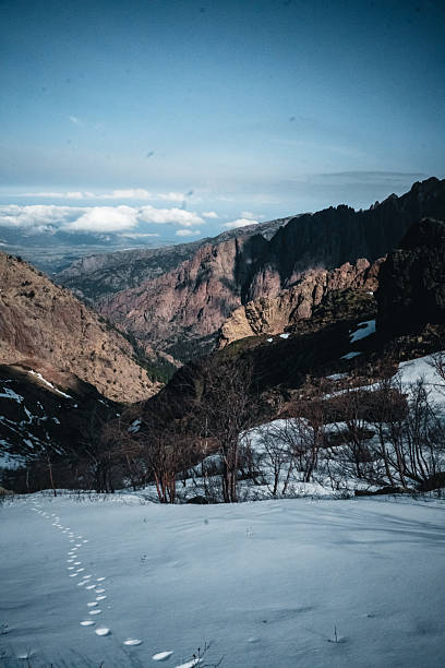 Footprints in snow up mountain ridge, Corsica