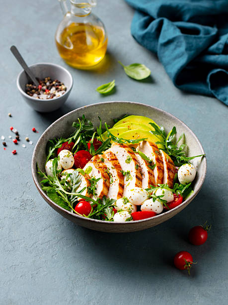istock Warm chicken salad with avocado and mozzarella cheese. Grey background. 2206253670