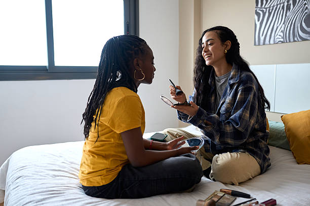 istock Two young women applying makeup on bed in bedroom 2206255813