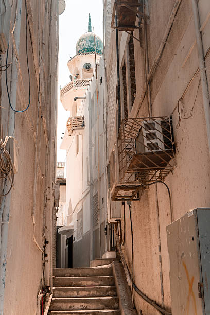 View up narrow street to minaret, Oman
