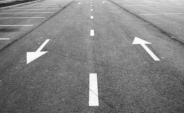 istock Road with arrows indicating directions in black and white. 2206257083