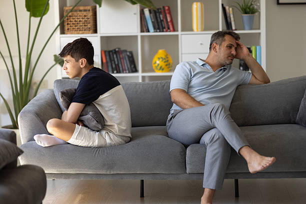 istock Annoyed young father sitting back to back with little son. 2206260925