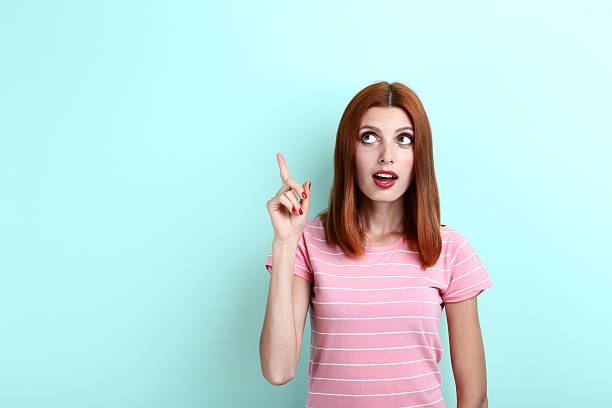 istock Young redhaired woman on mint background 2206261265