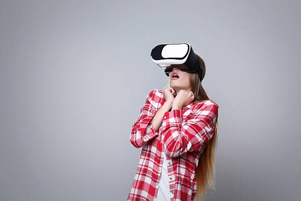 istock Young woman in virtual reality goggles on grey background 2206262067