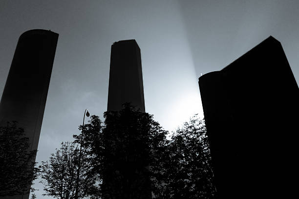 Backlighting of three buildings. Sunlight on a day of dense fog causes the metal buildings to cast an immense light into the sky.